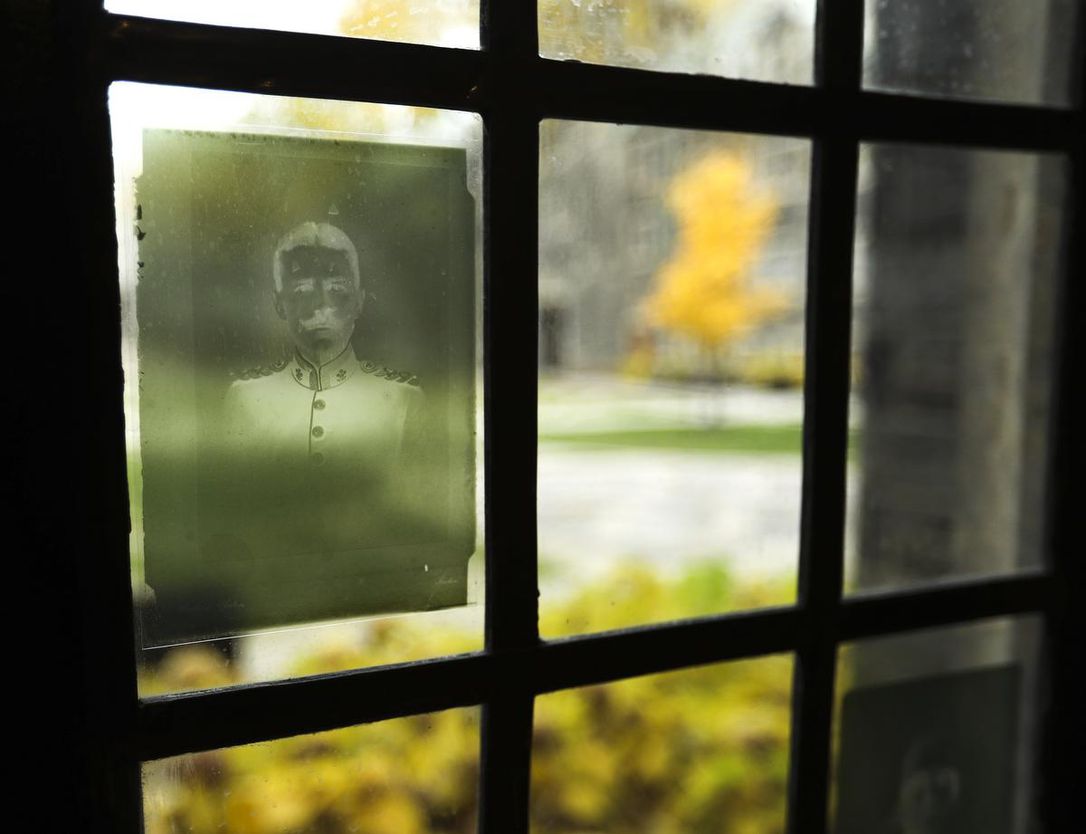 Adhesive reproductions of old photo negatives are attached to the windows overlooking a courtyard at U of T’s Trinity College. The college’s archives hold 210 glass-plate negatives of portraits from The War Memorial Volume of Trinity College, about 543 students and alumni who had served in the First World War. This picture shows William George Henry Bates.