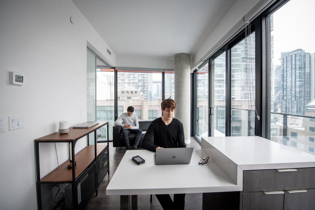 “We love the big windows and the view of the skyline. And you can’t beat the location,” says Erwan Roux (left), seen with partner Mikael Martinez, of their micro condo near Queen St. and University Ave.
